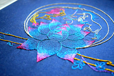 Embroidered design with lion, unicorn, and lotus in metallic thread on navy background
