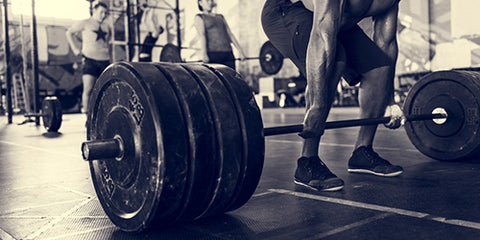 man lifting weights in dark gym