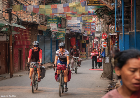 Jennifer Gurecki and Roz Groenewoud biking through the streets of Nepal.