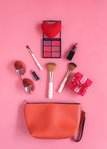 a pink makeup bag and makeup materials such as rouge, blusher, and eyeliner
