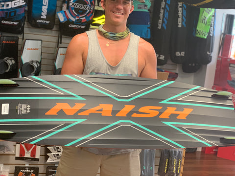 man holding Naish kiteboard