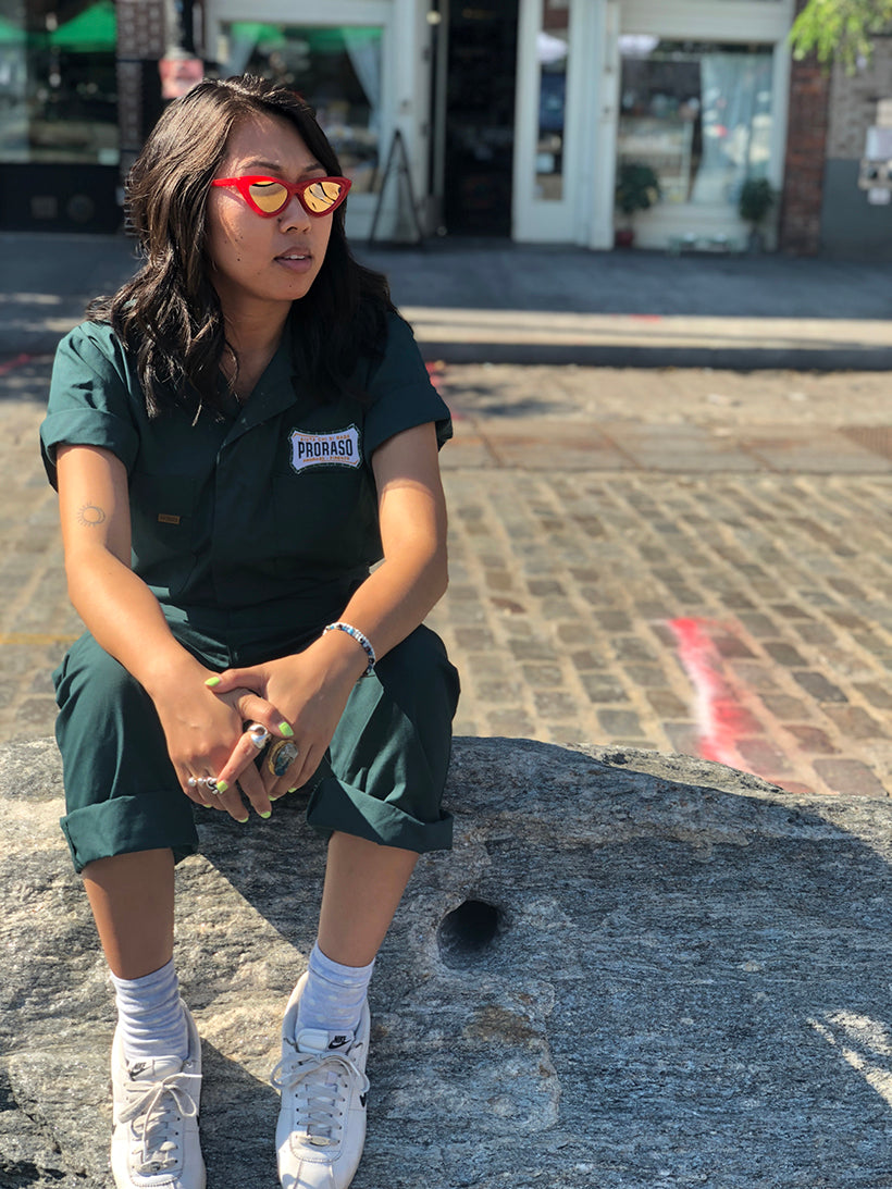 Proraso team member in a green jumpsuit sitting on the sidewalk