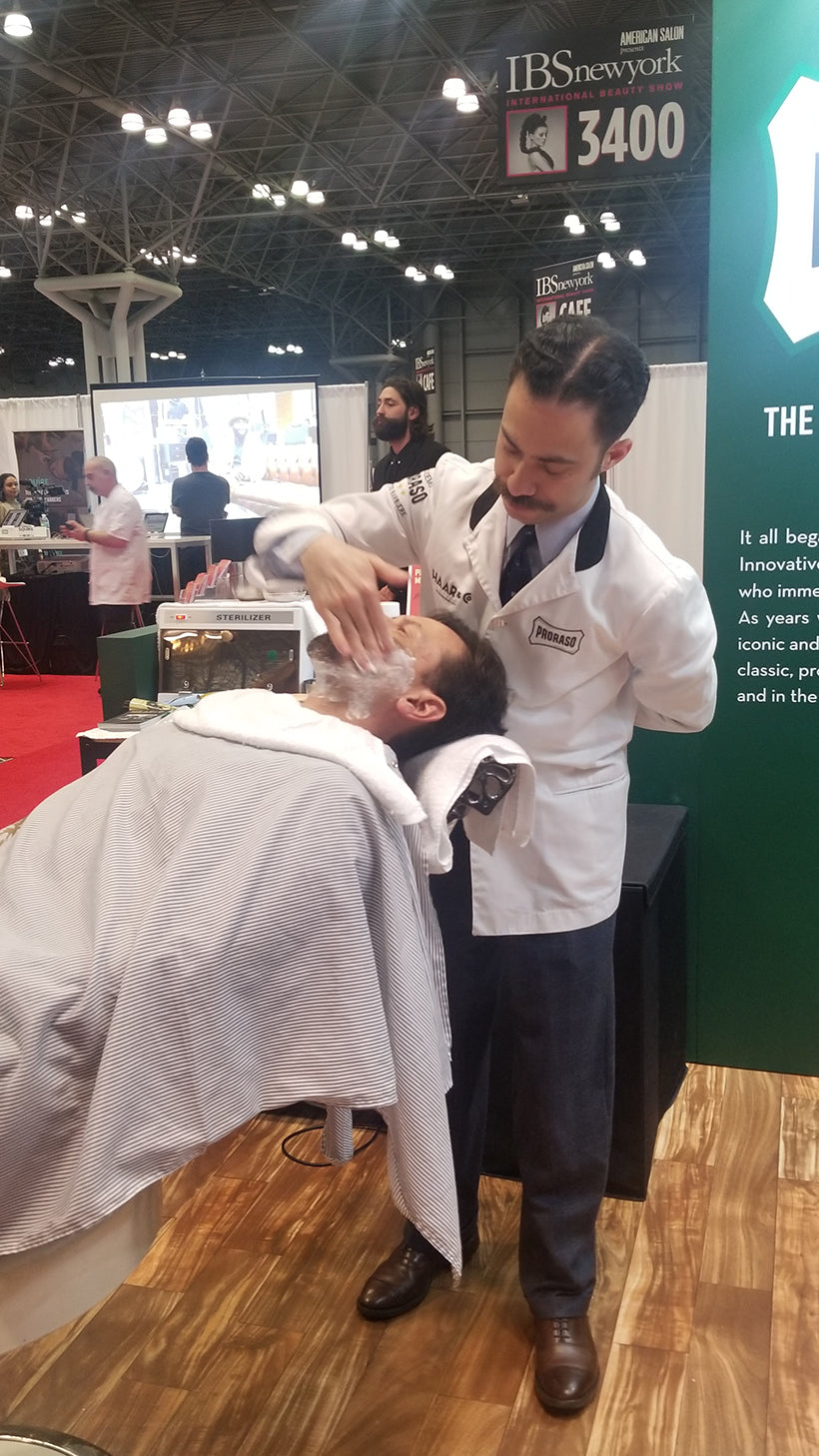 Proraso Master Barber Michael Haar applying shave cream to a client who is reclining in a barber chair.