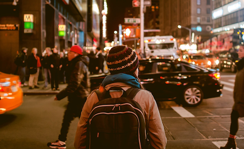 person with backpack walking in citty