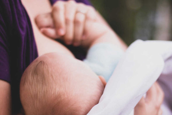 mom breastfeeding baby on topponcino
