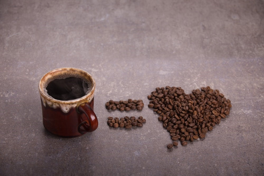 Coffee cup with coffee beans in the shape of a heart