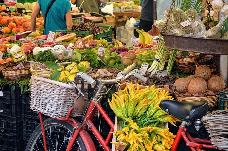 a bike in a greengrocers surrounded by vegetables