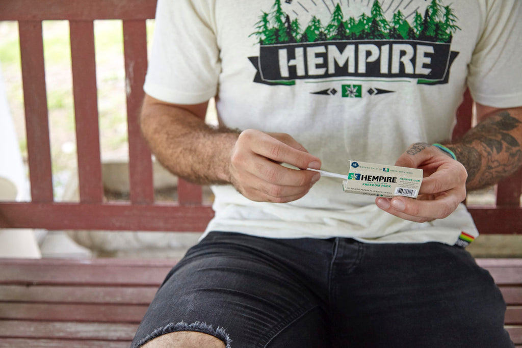 Man in hempire shirt rolling with Hempire papers