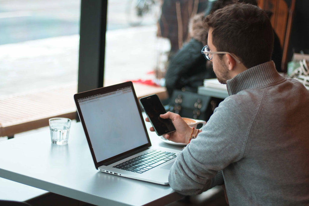 Young professional exposed to HEV light while working on laptop in cafe