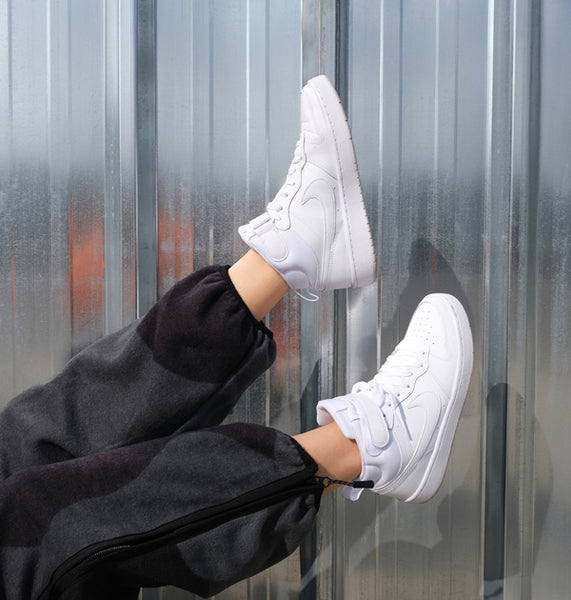 Person wearing white Nike Air Force sneakers.