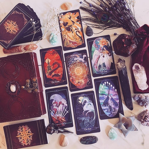 This photo features the Triple Goddess Moonstone journal in Ox-Blood brown, the Children of Litha tarot,  and the wine velvet tarot pouch (all available at Xiahunt.com)