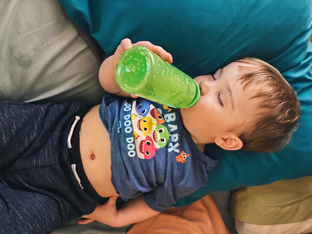 Sleepy toddler drinking formula out of bottle