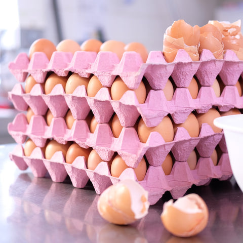 Free Range Eggs stacked in pink trays for baking