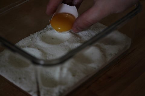 egg yolk being placed onto salt bed