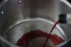 pouring red wine into pot