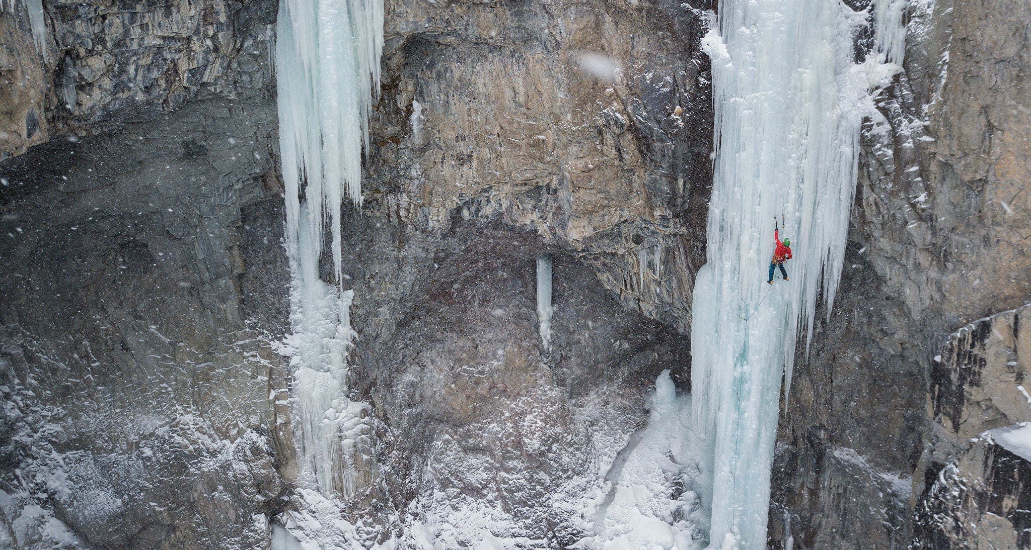 Ice climber climbing a huge formation