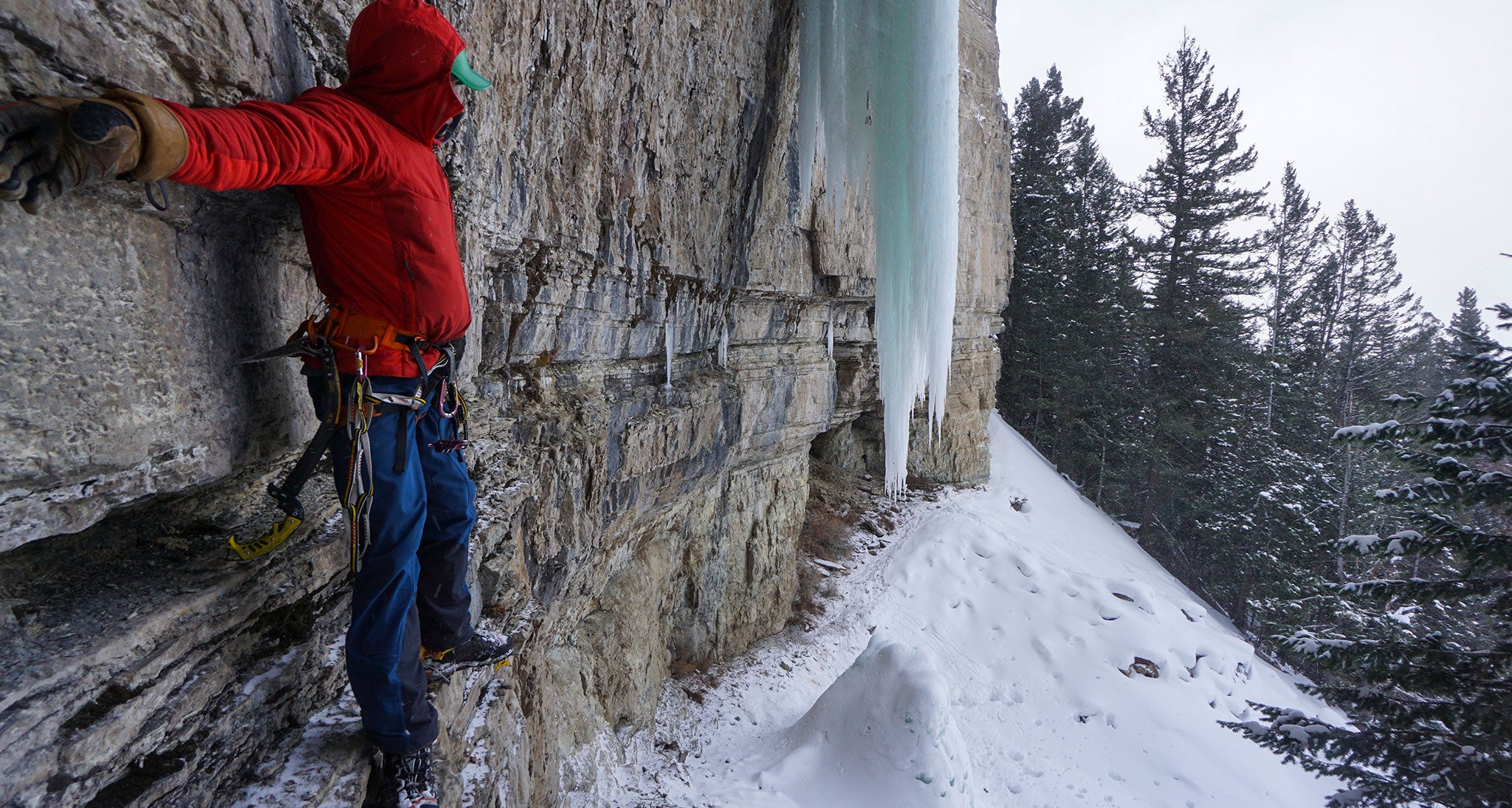 Climber stands flush against a rock wall