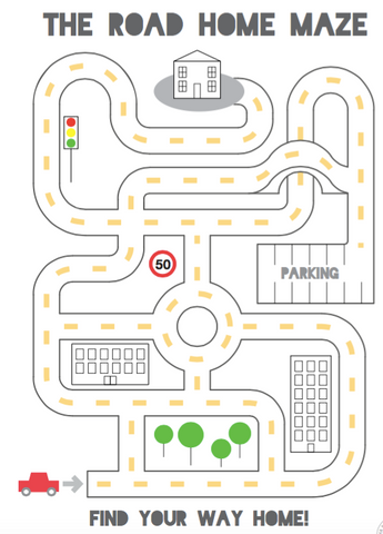 A children's maze titled "The road home maze" where the maze is in the shape of a road layout from above with buildings, speed signs, traffic light and parking. An arrow points from a car in one corner and a house is in the opposite corner