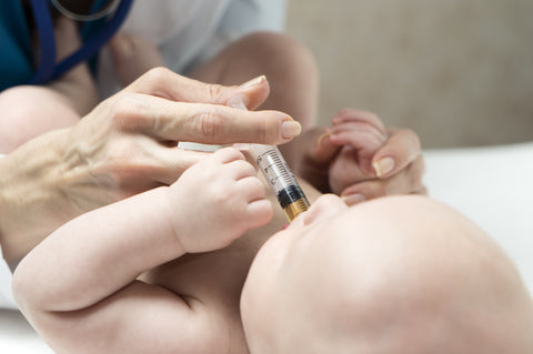 Picture of a baby being given medicine via syringe in the mouth