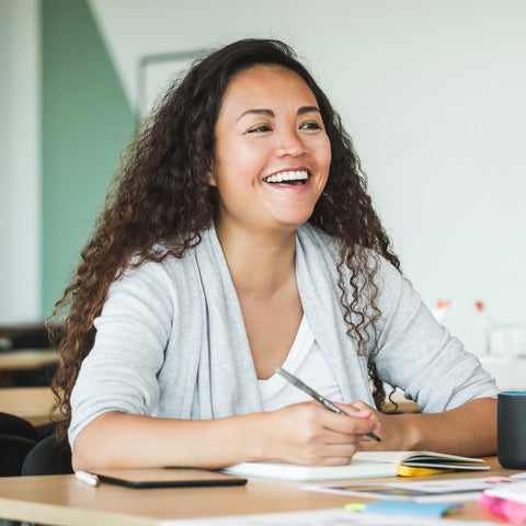 Happy teacher at desk.