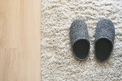 Slipping into the home life, grey slippers on white mat