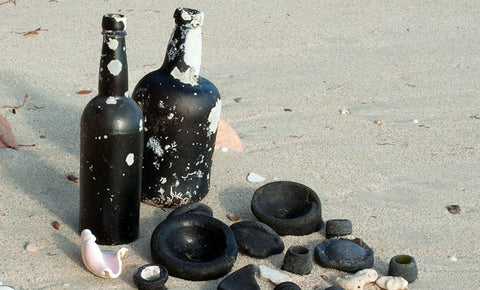 black glass bottles on beach sea glass