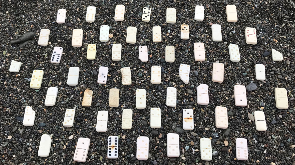 beachombed dominos on black pebble beach