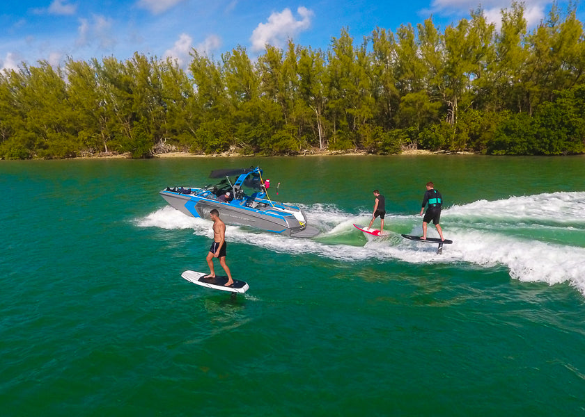 The Next Level Watersports team riding a hydrofoil, wakesurf and efoil behind a Nautique wakesurf boat in Miami, FL