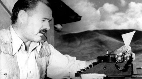 Memoirist Ernest Hemingway at his typewriter writing