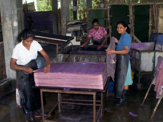 ladies making large sheets of handmade elephant dung paper
