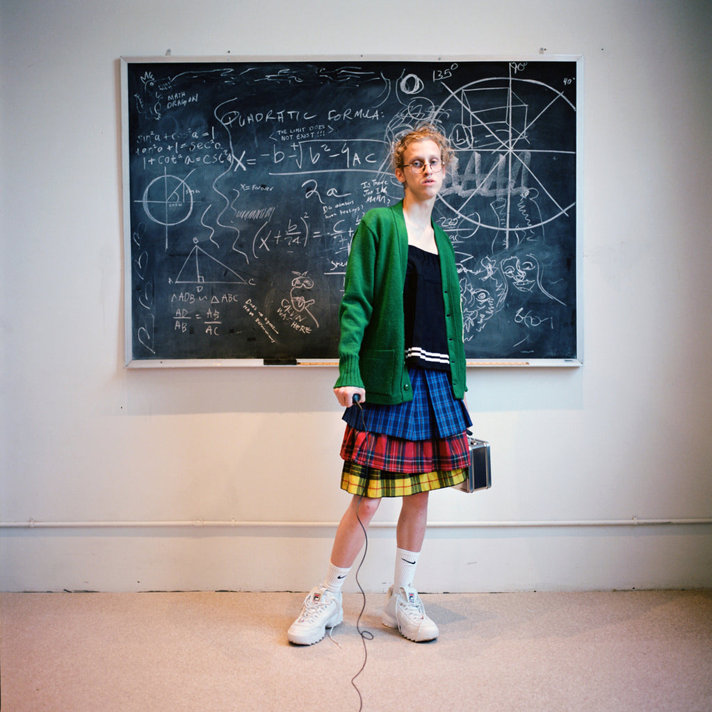 model in front of chalk board with shutter release in hand. 