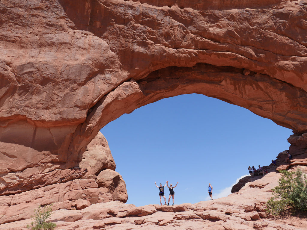 duo posing with arms up inside the north window arch.