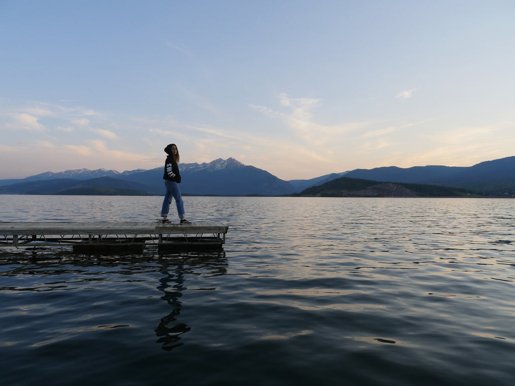 a person standing on a dock in a lake.