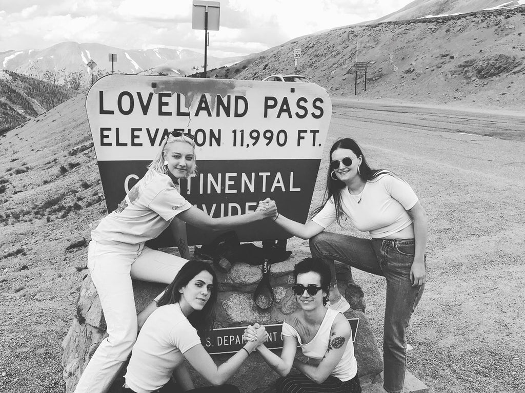group of people standing in front of a sign that says loveland pass.