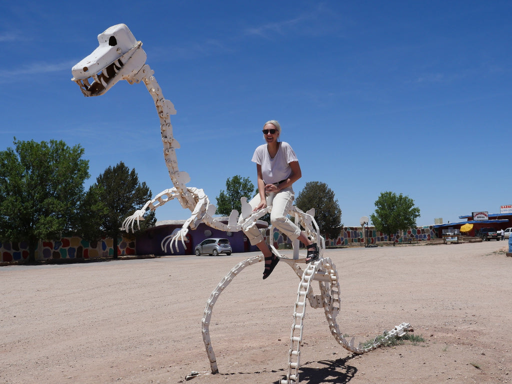 a person riding a skeleton dinosaur.