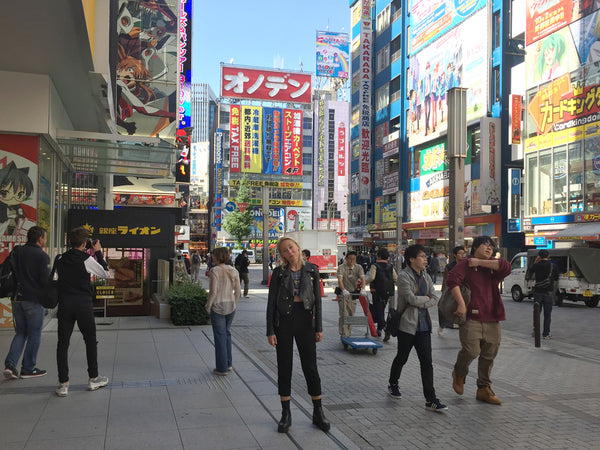 a person posing surrounded by people walking down a city street.