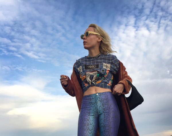 a person in purple leggings standing with cloudy sky in the background.