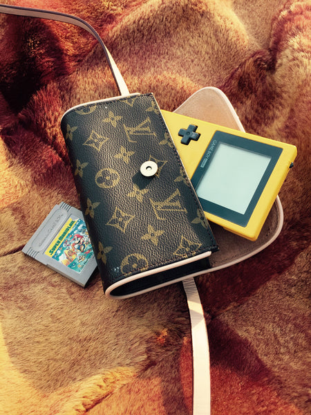 yellow game boy and louis vuitton purse.