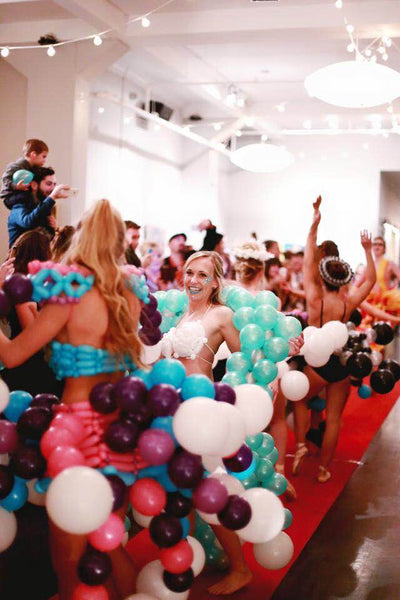 models dancing on the runway in balloon dresses. 