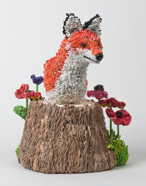 bust of fox on stump with flowers.