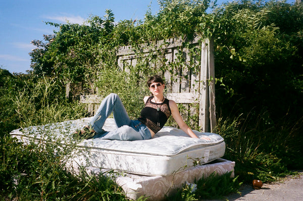 a person laying on top of a mattress in a field.