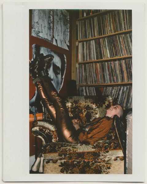 tess laughing feet up in front of records.