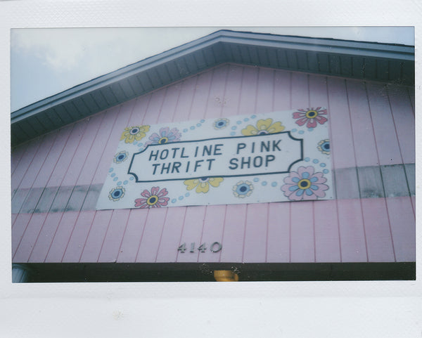 a pink building with a sign that says hotline pink thrift shop.