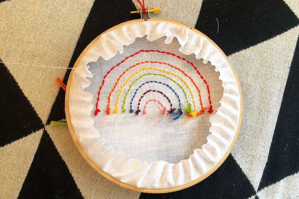 rainbow threads stitched in embroidery hoop with chain stitch finishing 