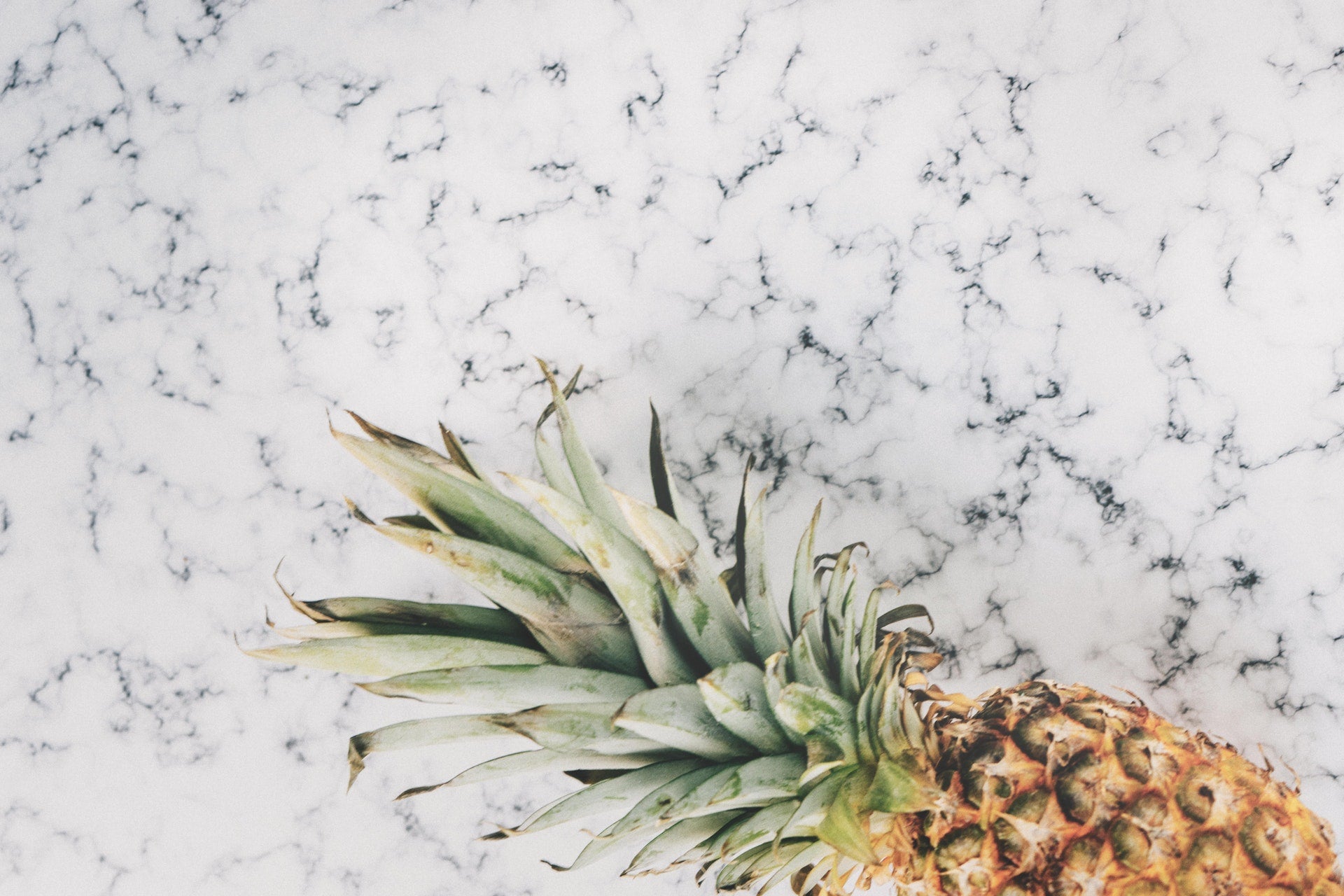 pineapple on marble counter background flat lay eveandelle