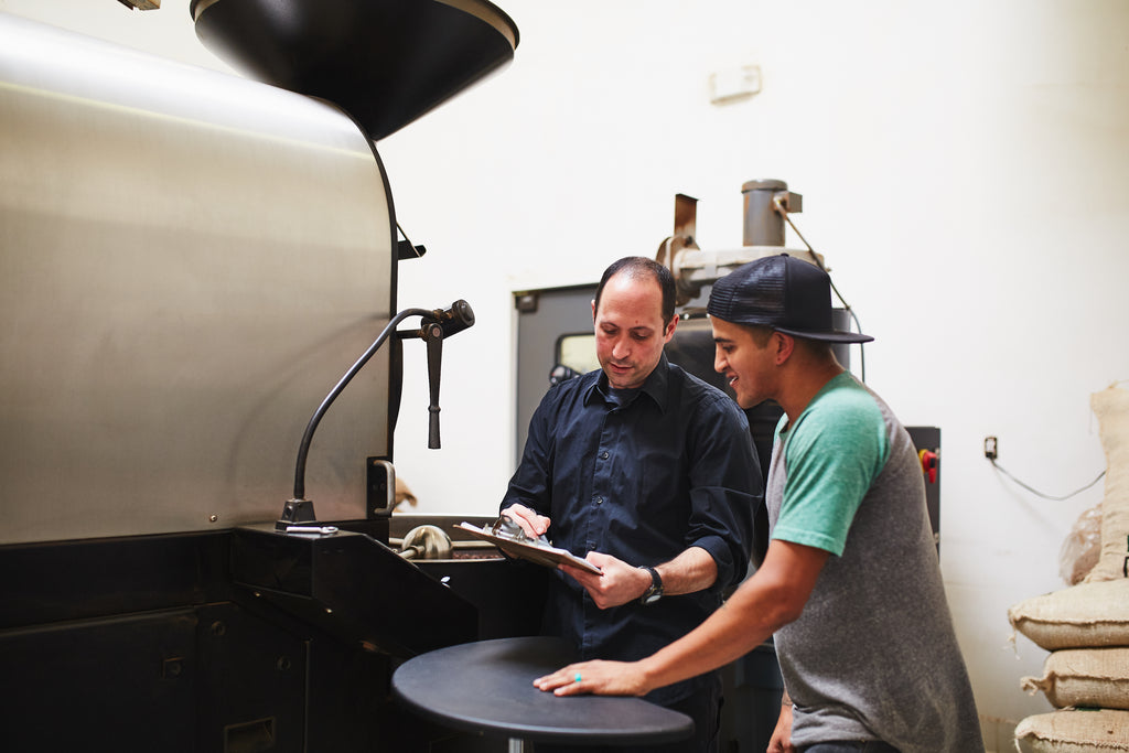 two roasters in front of a roasting machine