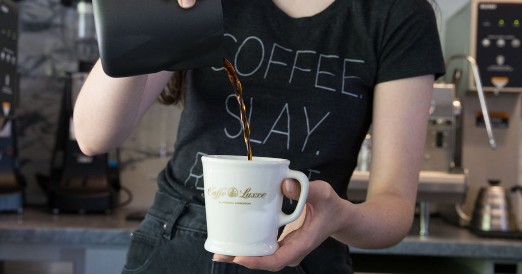 woman pouring coffee into caffe luxxe mug