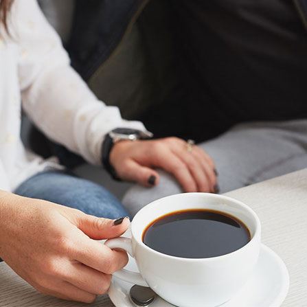 woman's hand holding a coffee cup full of coffee