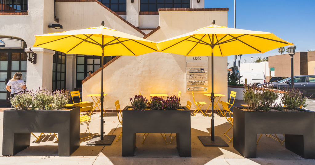 exterior of caffe luxxe palisades where two large yellow umbrellas cover a seating area