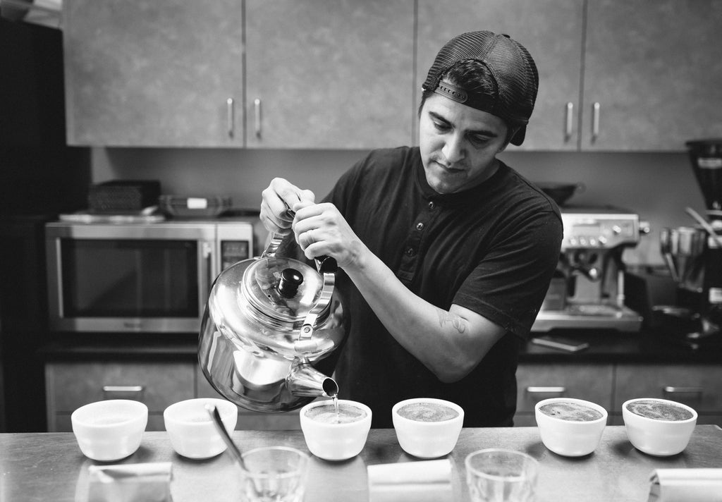 black & white photo of man preparing a coffee cupping